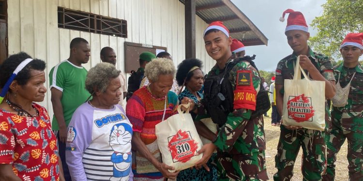 Nuansa Natal Yang Penuh Kasih, Satgas Yonif 310/KK Bagikan Sembako Untuk Warga Tulo Dan Kutdol